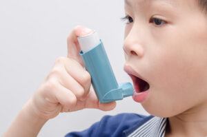 kid using asthma spray