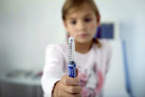 kid holding syringe