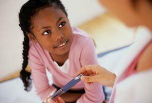 kid being monitored blood sugar level